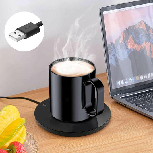 Savies electric cup warmer with steam rising from black mug next to laptop on wooden desk
